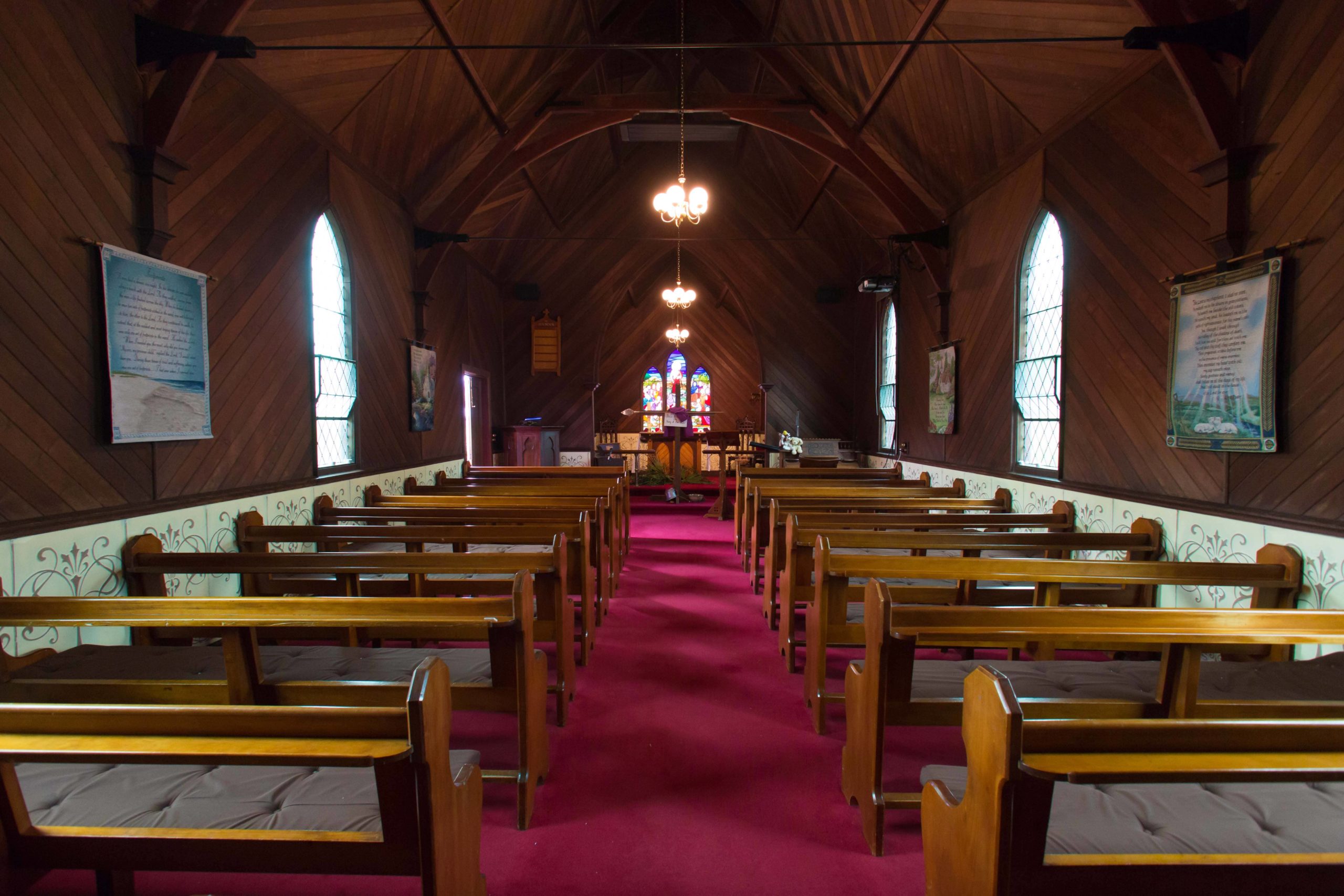 A row of pews in an empty chapel