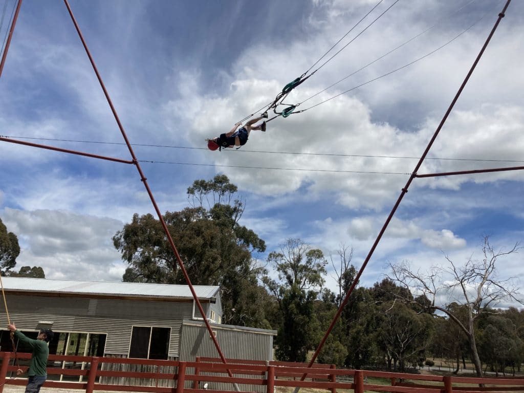 Student flying on giant swing