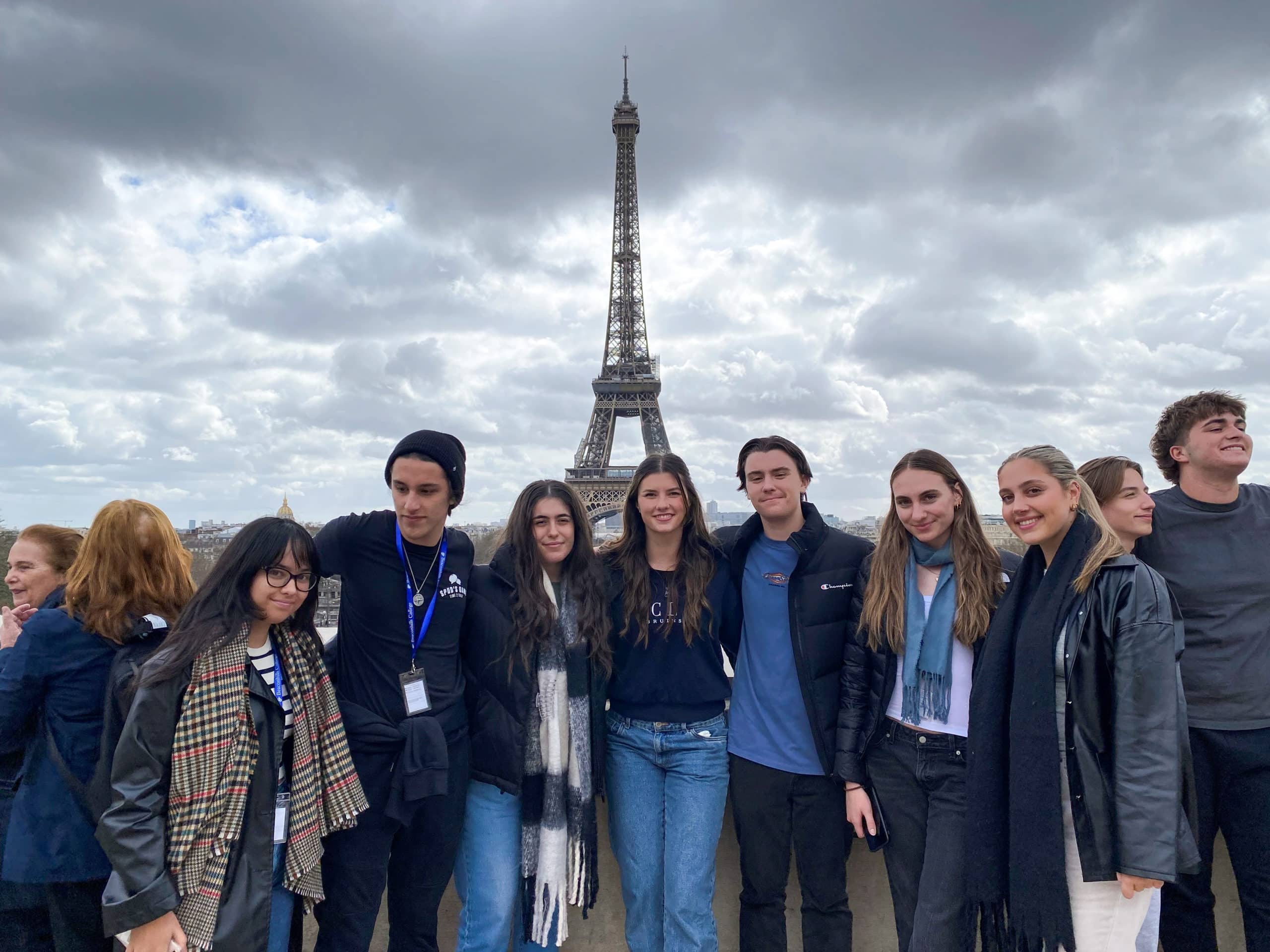 A group of Beaconhills students standing in front of the Eiffel Tower.
