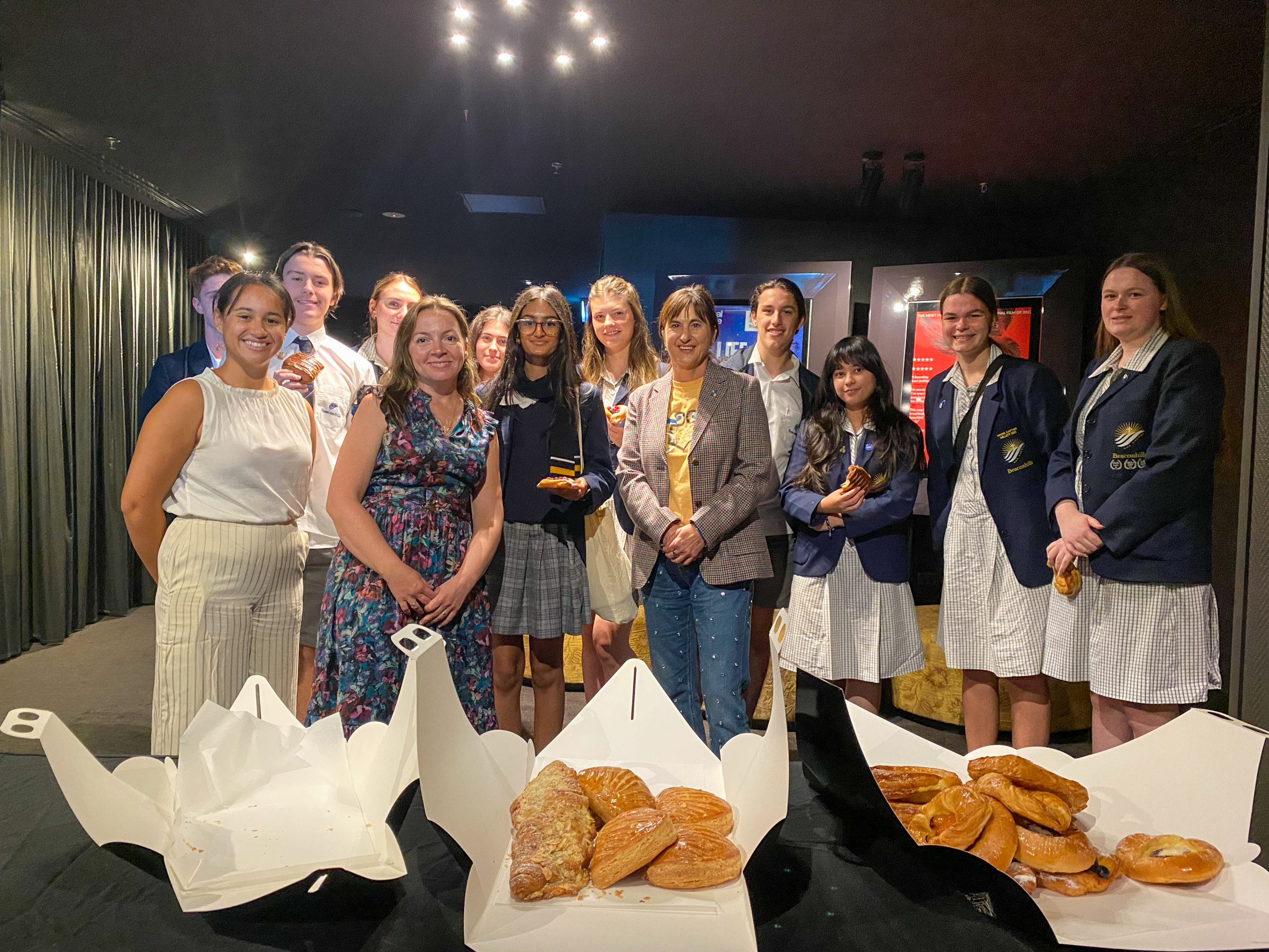 Beaconhills College students posing for a group photo in front of French pastries,