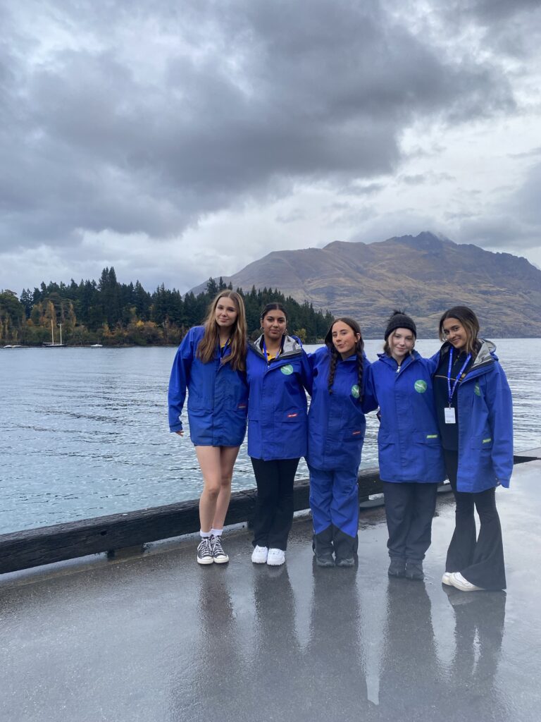 Five grils in front of lake