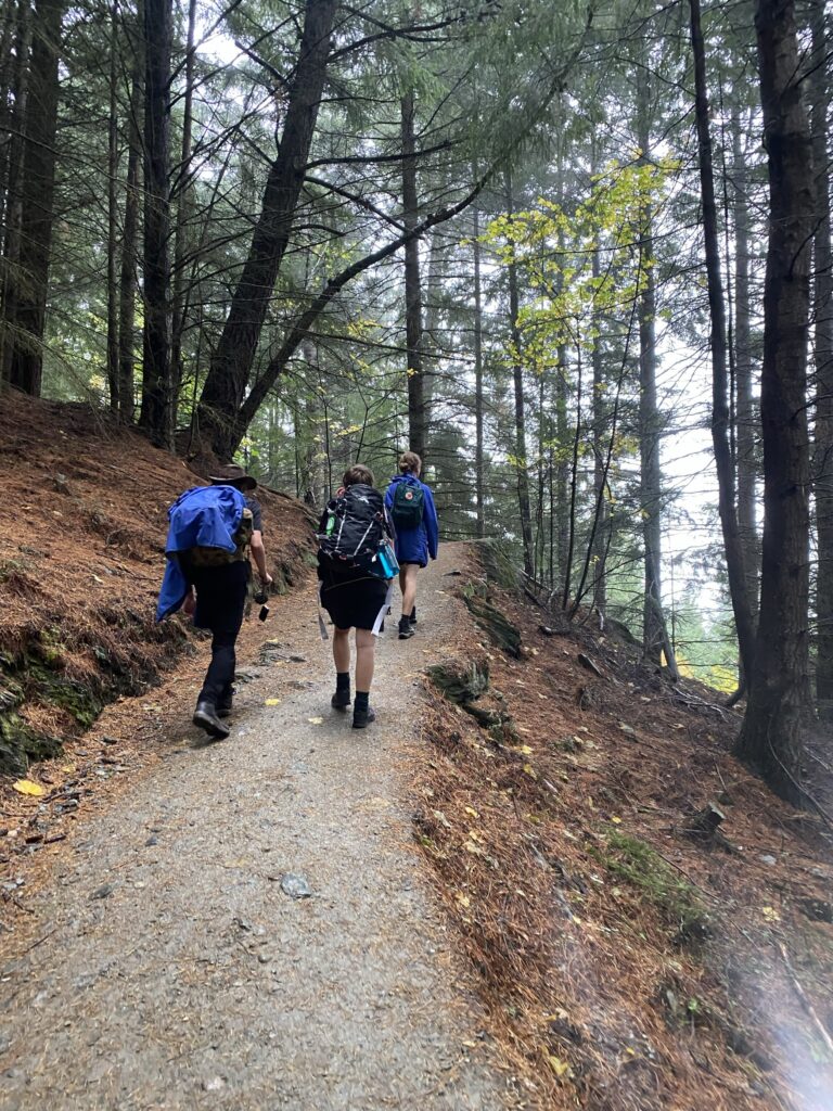 Three students hiking up path