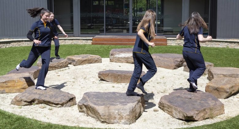 Students running on circle of stones