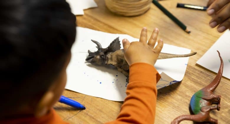 Student holding dinosaur toy at Beaconhills