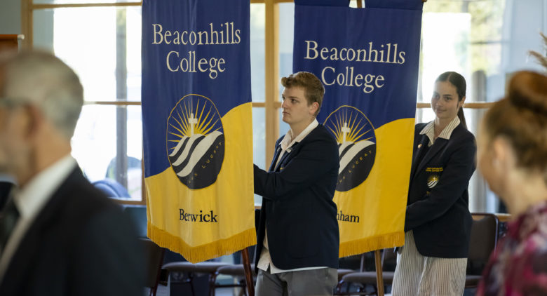 Girl and boy students carrying College flags