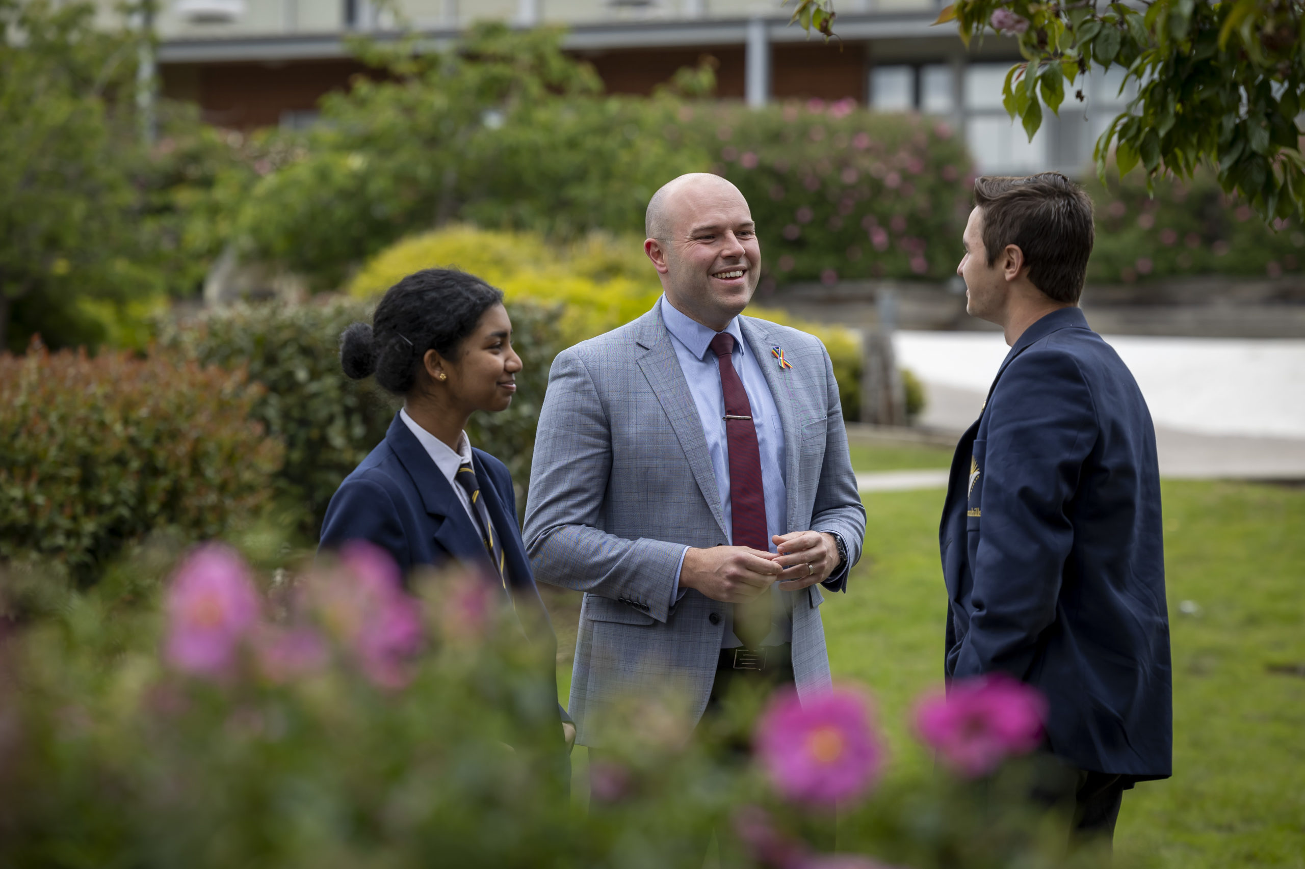 Teacher in a suit talking with two students