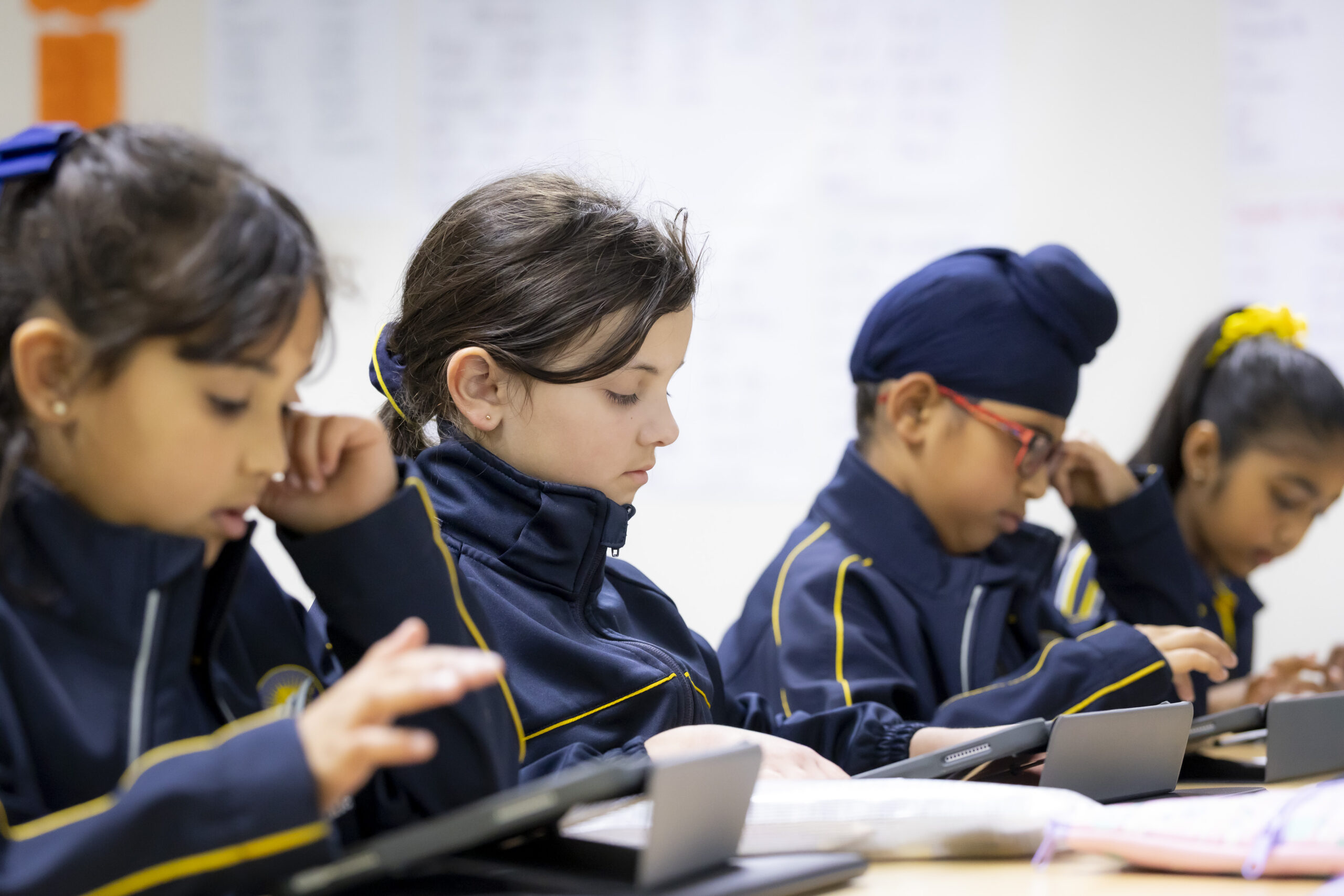 Four students doing work at desk